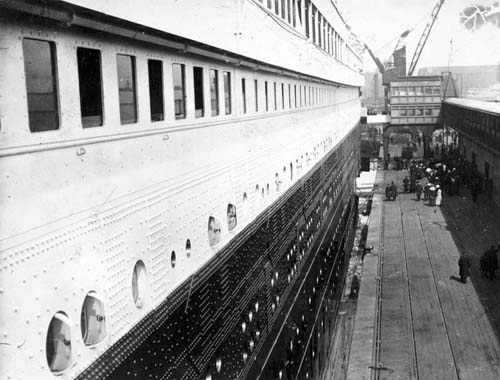Прямо перед тем, как зайти на борт Титаника, Фрэнк Браун сделал этот снимок, глядя вниз, вдоль судна. Вдали видны сходни для пассажиров второго класса, идентичные тем, на которых стоит он.