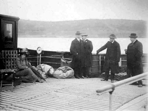 Еще один снимок посыльного судна "Ирландия" в Коркской гавани, на котором изображен писатель Р. В. Мэй (в центре), стоящий прямо за своим братом Стэнли Мэем.